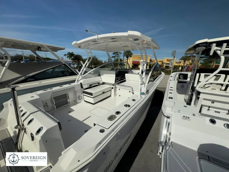 Slide: The Image of 2024 Blackfin 272 DC boat at a marina, showcasing spacious deck and seating. - 10