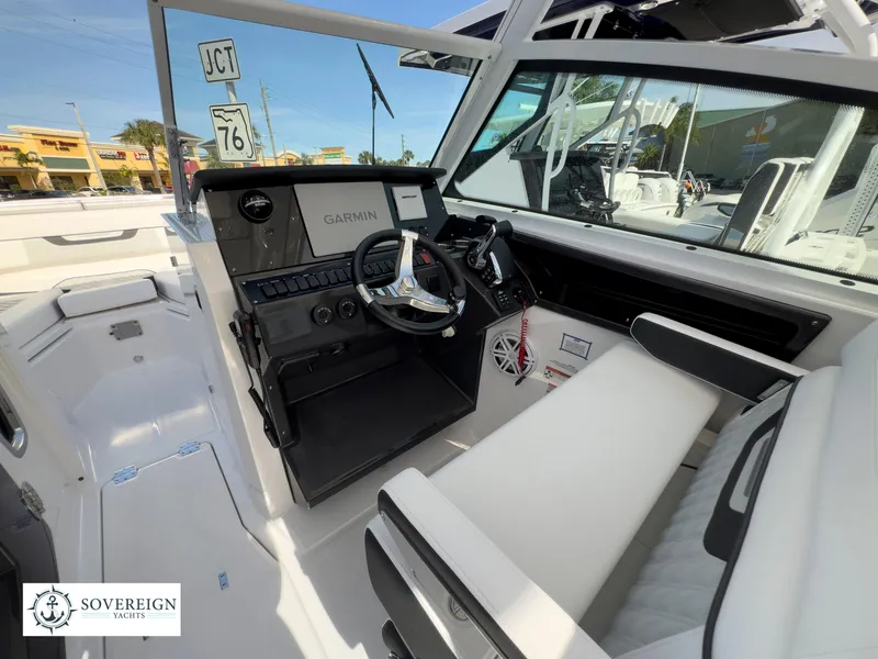 Slide: The Image of 2024 Blackfin 272 DC boat cockpit with Garmin navigation system and Sovereign Yachts logo. - 28