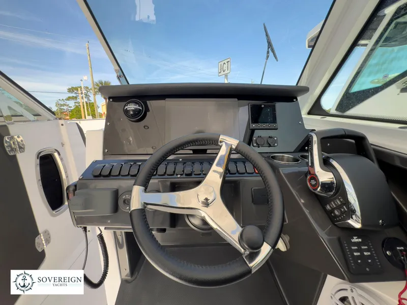 Slide: The Image of 2024 Blackfin 272 DC boat helm with steering wheel and control panel. - 30