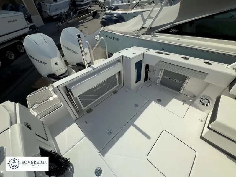 Slide: The Image of 2024 Blackfin 272 DC boat deck with twin Mercury engines and Sovereign Yachts logo. - 42