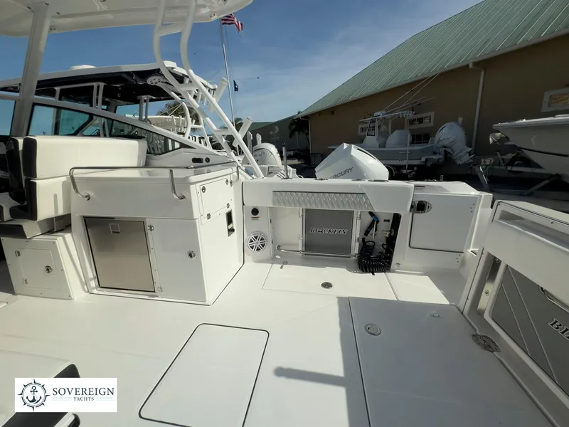 Slide: The Image of 2024 Blackfin 272 DC boat deck with storage compartments and fishing equipment. - 47