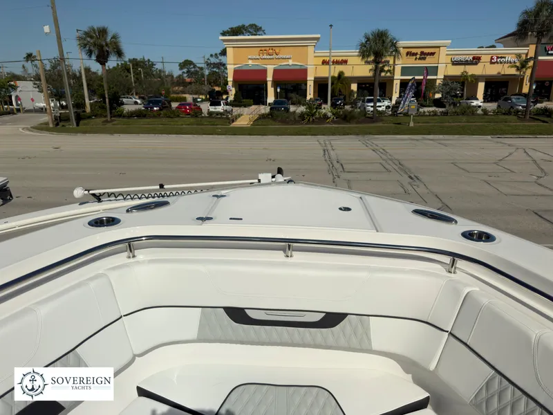 Slide: The Image of 2024 Blackfin 302 boat bow with seating, Sovereign Yachts logo, shopping center in background. - 24