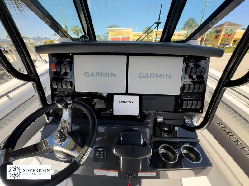Slide: The Image of 2024 Blackfin 302 boat dashboard with dual Garmin displays and Mercury controls. - 29