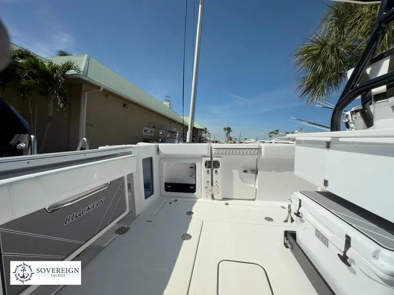 Slide: The Image of 2024 Blackfin 302 boat deck with Sovereign Yachts logo, docked under clear sky. - 38
