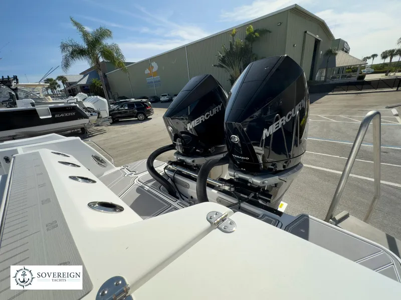Slide: The Image of 2024 Blackfin 302 boat with twin Mercury outboard engines at a marina. - 48