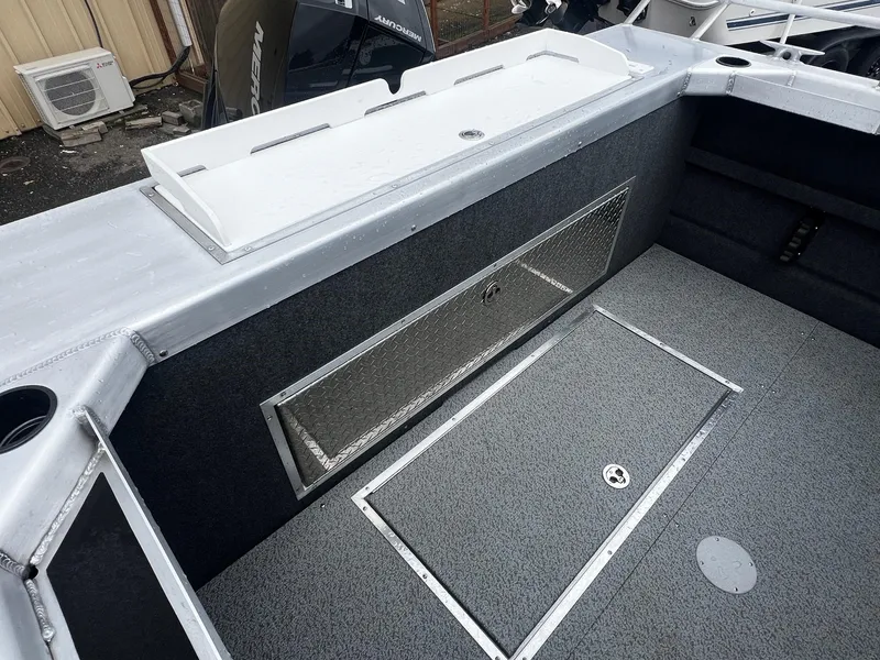 Slide: The Image of 2024 Thunder Jet 21 Chinook OS boat interior with storage compartments and fishing rod holders. - 15