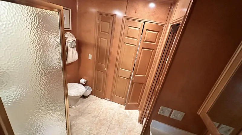 Slide: The Image of 2005 Fantasy 18 x 80 houseboat bathroom with wooden cabinets and frosted glass shower. - 12