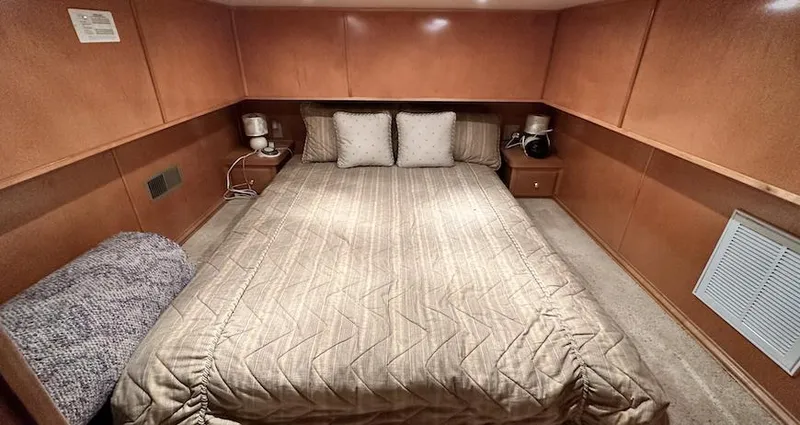 Slide: The Image of Luxurious bedroom in a 2005 Fantasy 18 x 80 houseboat with cozy bedding and wooden paneling. - 19