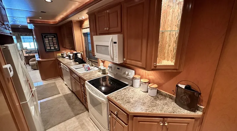 Slide: The Image of Spacious kitchen in a 2005 Fantasy 18 x 80 houseboat with modern appliances and wooden cabinetry. - 26