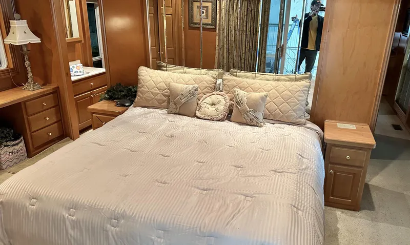 Slide: The Image of Luxurious bedroom in a 2005 Fantasy 18 x 80 houseboat with a large bed and wooden decor. - 5