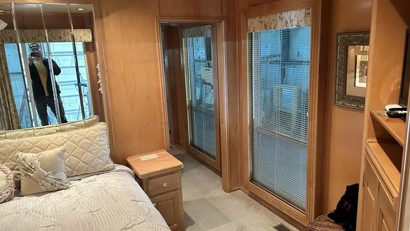 Slide: The Image of Interior of a 2005 Fantasy 18 x 80 houseboat bedroom with wooden decor and large windows. - 6