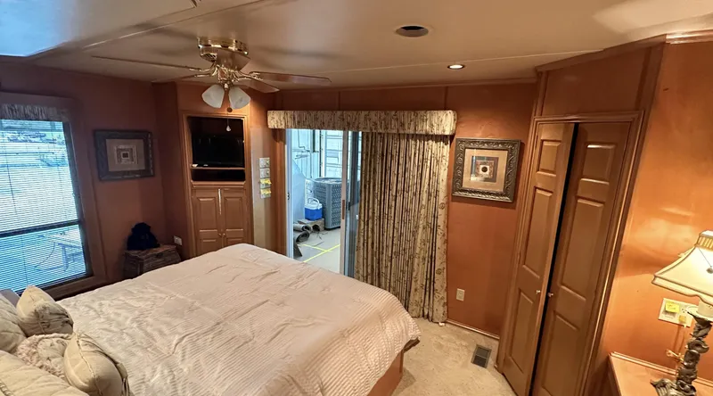 Slide: The Image of Cozy bedroom in 2005 Fantasy 18 x 80 houseboat with wood paneling and ceiling fan. - 7