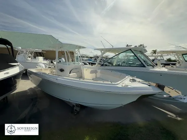 Slide: The Image of 2024 Sailfish 242 CC boat displayed at a marina under a cloudy sky. - 0