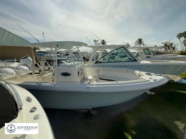 Slide: The Image of 2024 Sailfish 242 CC boat displayed outdoors at a yacht dealership. - 1