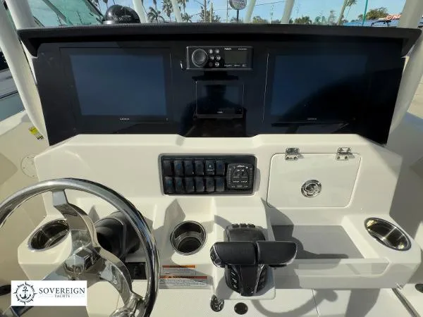 Slide: The Image of 2024 Sailfish 242 CC boat dashboard with dual screens and control panel. - 10