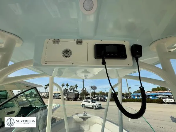 Slide: The Image of 2024 Sailfish 242 CC boat console with radio and storage compartment, Sovereign Yachts logo visible. - 12