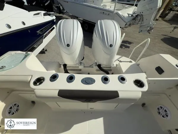 Slide: The Image of 2024 Sailfish 242 CC boat with dual outboard engines and fishing rod holders. - 15