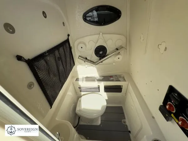 Slide: The Image of 2024 Sailfish 242 CC boat interior with compact marine toilet and storage features. - 17