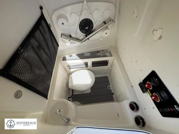 Slide: The Image of 2024 Sailfish 242 CC boat interior with compact marine toilet and storage features. - 18