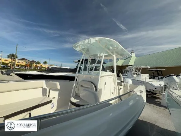 Slide: The Image of 2024 Sailfish 242 CC boat displayed at Sovereign Yacht dealership under clear skies. - 20