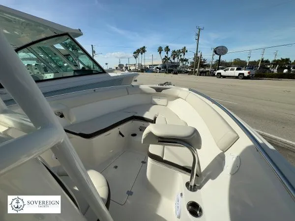 Slide: The Image of 2024 Sailfish 242 CC boat interior with seating, parked near a road. - 29