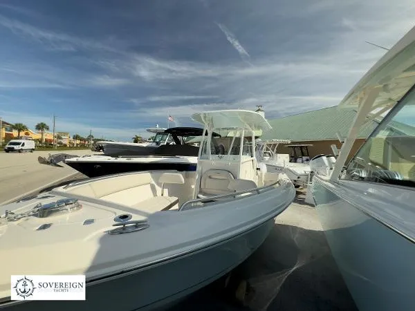Slide: The Image of 2024 Sailfish 242 CC boat displayed at Sovereign Yachts dealership under clear skies. - 3