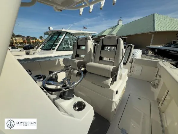 Slide: The Image of 2024 Sailfish 312 boat interior with dual captain's chairs and steering wheel, Sovereign Yachts logo. - 17