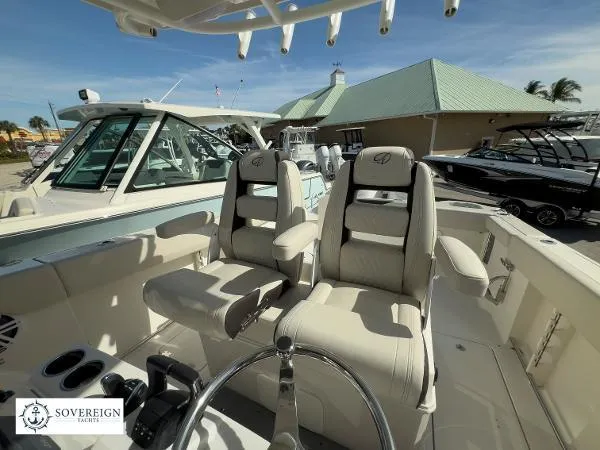 Slide: The Image of 2024 Sailfish 312 boat interior with dual captain's chairs at Sovereign Yachts dealership. - 19