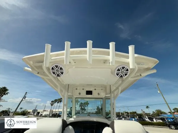 Slide: The Image of 2024 Sailfish 312 boat with rod holders and speakers under a clear blue sky. - 21