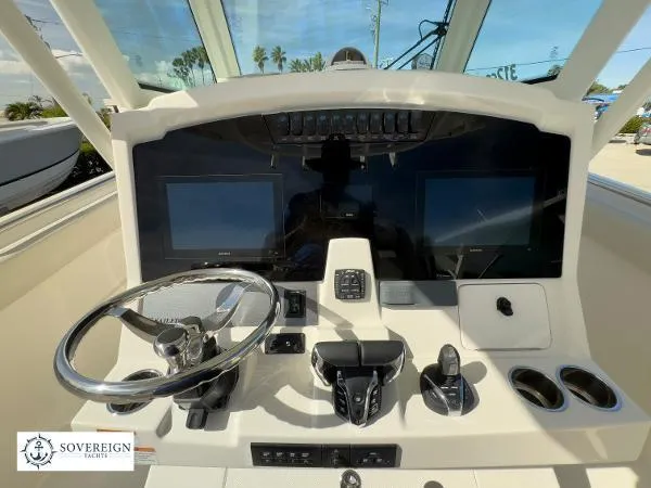 Slide: The Image of 2024 Sailfish 312 boat dashboard with dual screens and steering wheel. - 23