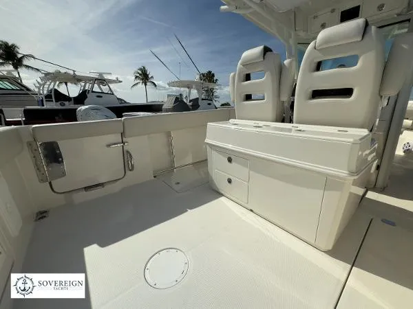 Slide: The Image of 2024 Sailfish 312 boat interior with seating and storage, docked under clear skies. - 29