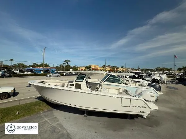 Slide: The Image of 2024 Sailfish 312 boat displayed at Sovereign Yachts dealership under clear blue sky. - 3