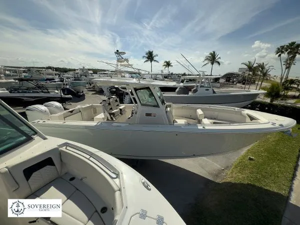 Slide: The Image of 2024 Sailfish 312 boat docked at a marina with palm trees and clear skies. - 7
