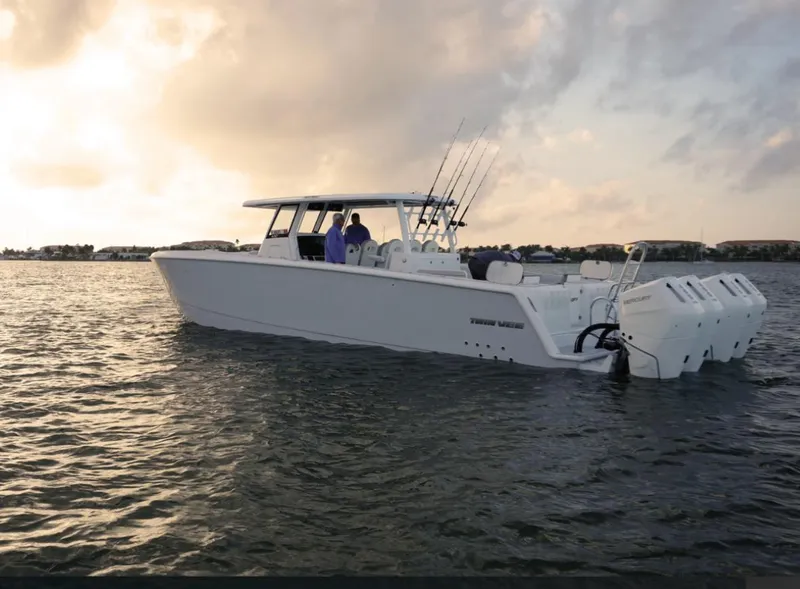 The Image of 2025 Twin Vee 400 GFX boat on calm water at sunset. - 0
