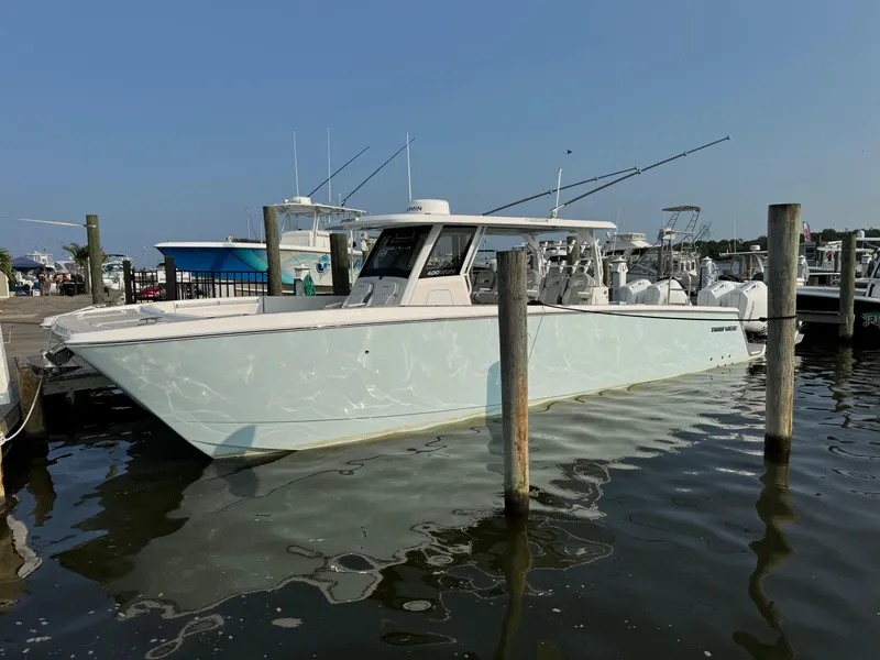 Slide: The Image of 2025 Twin Vee 400 GFX boat docked at a marina on a sunny day. - 12