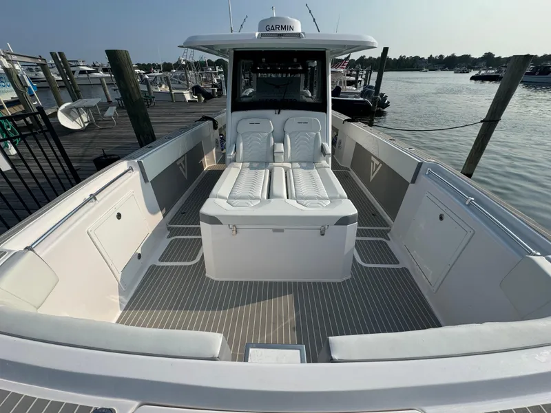 Slide: The Image of 2025 Twin Vee 400 GFX boat interior at dock, featuring spacious seating and modern design. - 13