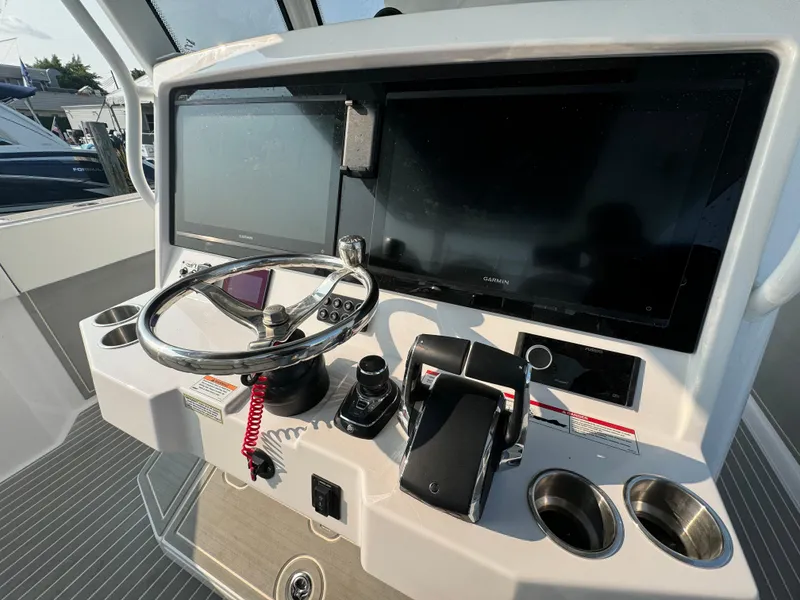 Slide: The Image of Twin Vee 400 GFX 2025 boat dashboard with steering wheel and dual screens. - 19