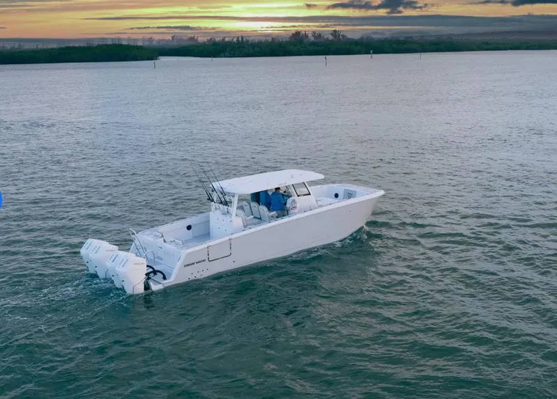 Slide: The Image of Twin Vee 400 GFX 2025 boat cruising at sunset on calm waters. - 2