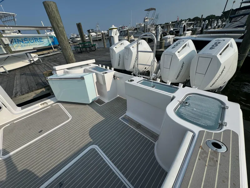 Slide: The Image of 2025 Twin Vee 400 GFX boat docked, showcasing deck and powerful outboard engines. - 21
