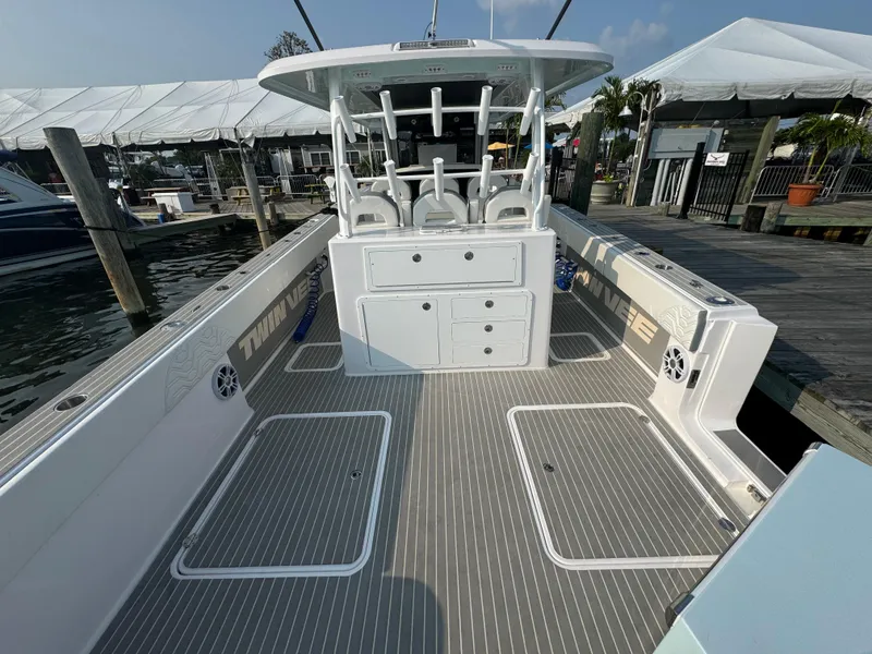 Slide: The Image of 2025 Twin Vee 400 GFX boat interior at dock, featuring spacious deck and seating. - 22