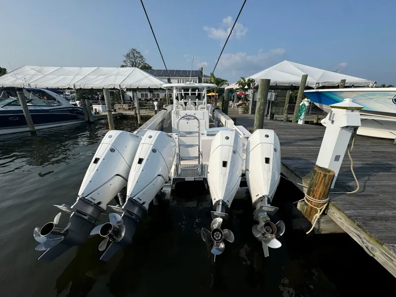 Slide: The Image of 2025 Twin Vee 400 GFX boat with four outboard engines docked at marina. - 23