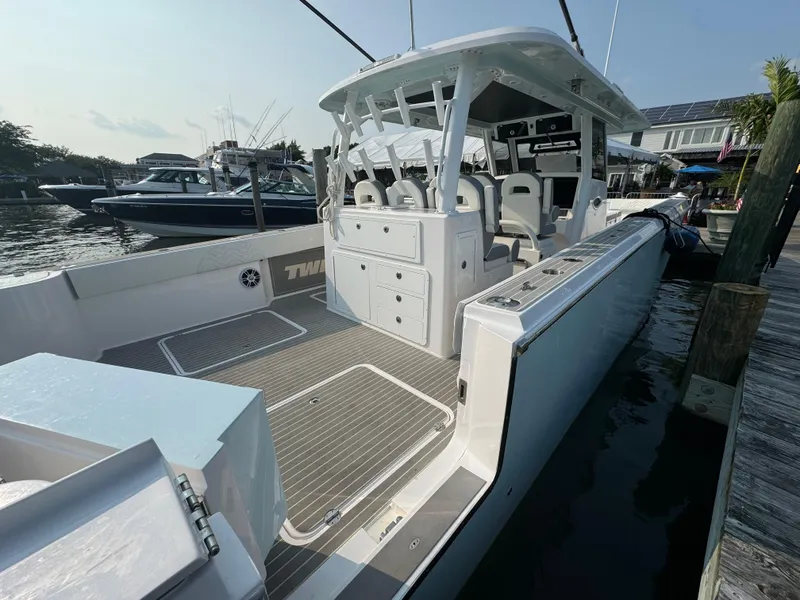 Slide: The Image of 2025 Twin Vee 400 GFX boat docked, showcasing spacious deck and modern design. - 24