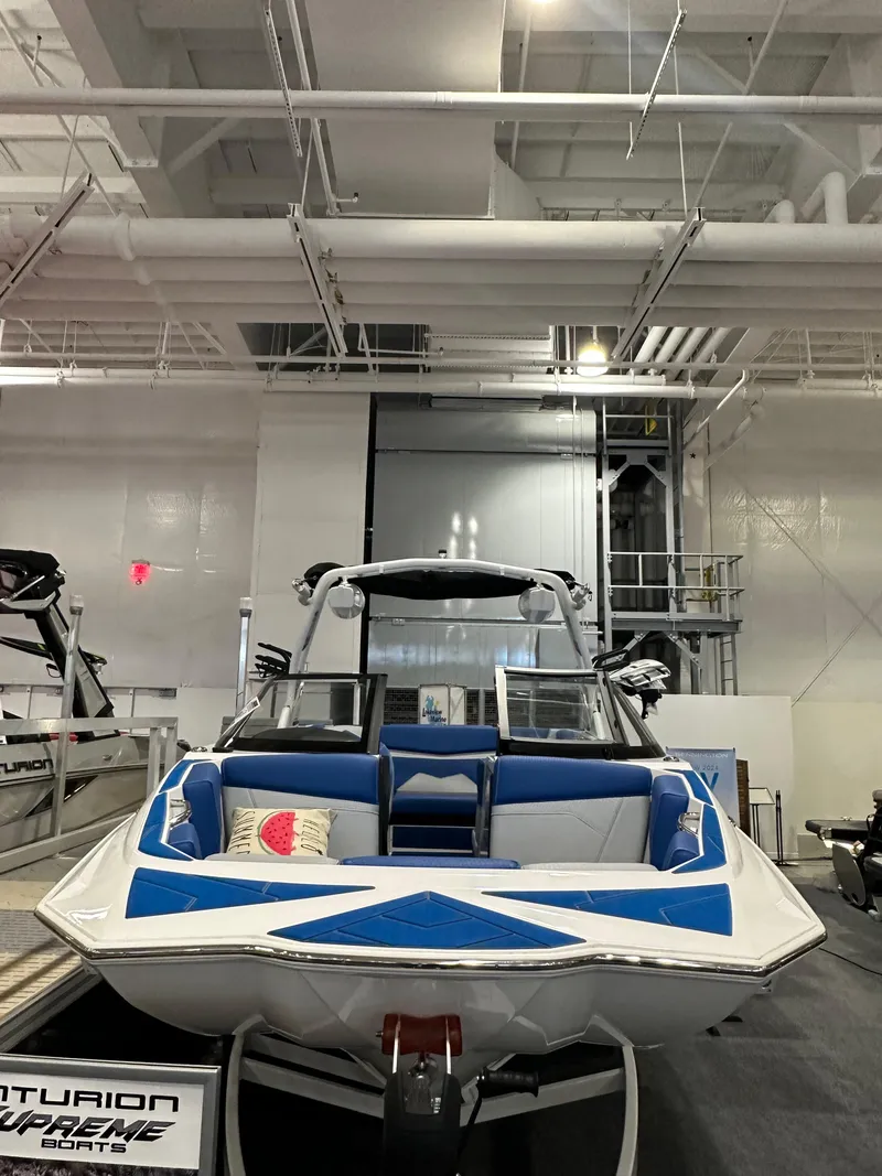 Slide: The Image of 2023 Supreme ZS212 boat displayed indoors with blue and white seating. - 1