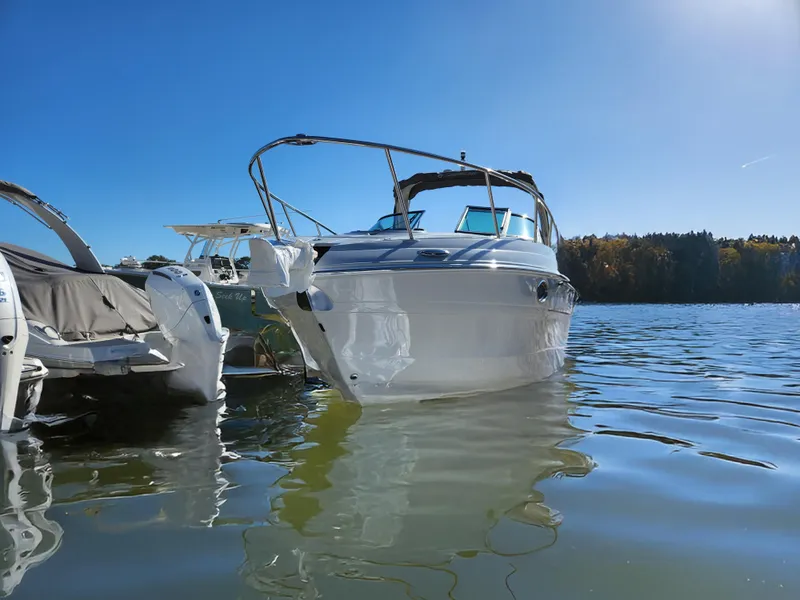 Slide: The Image of 2024 Crownline 280 CRX boat on calm water under clear blue sky. - 1