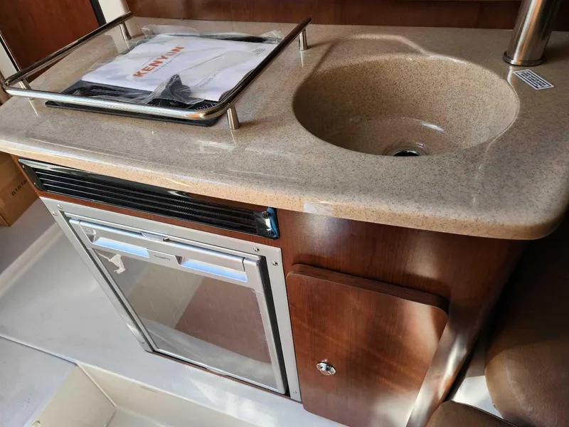 Slide: The Image of Compact kitchen area in the 2024 Crownline 280 CRX boat with sink and mini-fridge. - 14