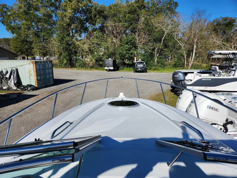 Slide: The Image of View from the bow of a 2024 Crownline 280 CRX boat in a storage yard. - 19