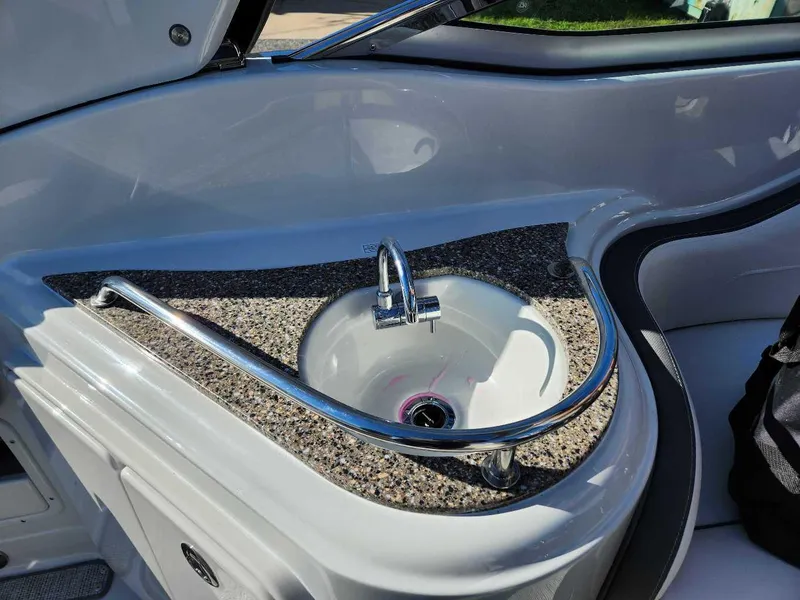 Slide: The Image of 2024 Crownline 280 CRX boat interior sink with granite countertop and chrome faucet. - 23