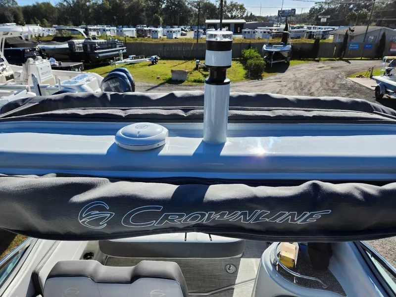 Slide: The Image of 2024 Crownline 280 CRX boat with covered seating and marina background. - 3