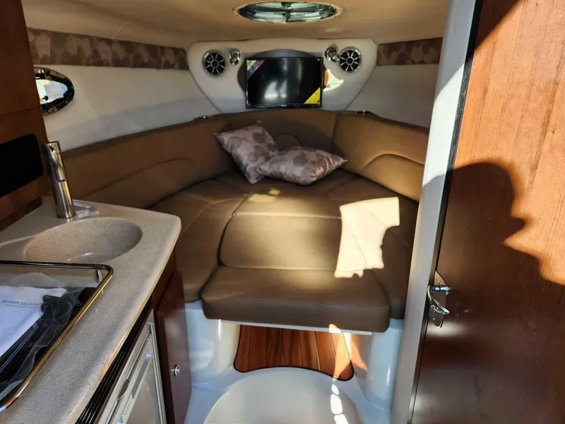Slide: The Image of Interior cabin of 2024 Crownline 280 CRX boat with bed, sink, and TV. - 6