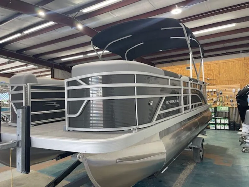 Slide: The Image of 2024 Bennington 20 SVL pontoon boat in showroom, featuring sleek design and canopy. - 3